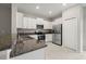 Bright kitchen with granite countertops, stainless steel appliances, and ample white cabinetry at 9716 Mulberry Marsh Ln, Sun City Center, FL 33573