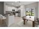 Bright kitchen features white cabinets, stainless steel appliances, and a breakfast bar open to the dining area at 9716 Mulberry Marsh Ln, Sun City Center, FL 33573