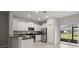 Bright kitchen features white cabinets, stainless steel appliances, and a breakfast bar open to the dining area at 9716 Mulberry Marsh Ln, Sun City Center, FL 33573