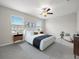 Bright main bedroom with carpet, a ceiling fan, a queen bed, and bedside tables at 9716 Mulberry Marsh Ln, Sun City Center, FL 33573