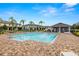 Community pool with palm trees and lounge chairs at 9716 Mulberry Marsh Ln, Sun City Center, FL 33573