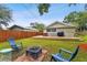 Well-maintained backyard featuring a wooden deck, fire pit, and chairs at 104 W Henry Ave, Tampa, FL 33604