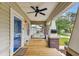 Inviting front porch featuring a classic porch swing, wood flooring, and a ceiling fan for a cozy outdoor experience at 104 W Henry Ave, Tampa, FL 33604