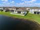 Aerial view of a home on a lake showing a manicured lawn and white picket fence at 11717 Navajo Sandstone St, Riverview, FL 33579