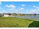 Lush backyard with manicured lawn and a white picket fence overlooking a tranquil pond at 11717 Navajo Sandstone St, Riverview, FL 33579