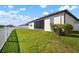 Well-maintained backyard with a white fence, lush grass, and partial views of the home's exterior at 11717 Navajo Sandstone St, Riverview, FL 33579