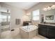 Luxurious bathroom featuring a soaking tub, dual vanities, granite countertops, and modern fixtures at 11717 Navajo Sandstone St, Riverview, FL 33579