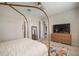 Spacious bedroom with neutral walls, a large dresser, television, and seamless flow into the ensuite bathroom at 11717 Navajo Sandstone St, Riverview, FL 33579