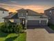 Beautiful single-Gathering home showcasing a three-car garage, brick driveway, and meticulously landscaped front yard at 11717 Navajo Sandstone St, Riverview, FL 33579