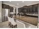 Open-concept kitchen with dark wood cabinets, stainless appliances, granite counters, and seating at the island at 11717 Navajo Sandstone St, Riverview, FL 33579