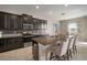 Charming kitchen featuring dark wood cabinets, a large island with seating, and modern stainless steel appliances at 11717 Navajo Sandstone St, Riverview, FL 33579