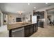 Open kitchen and living area with modern appliances, dark cabinets and tiled floors at 11717 Navajo Sandstone St, Riverview, FL 33579