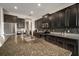 Modern kitchen featuring dark cabinets, granite counters, stainless steel appliances and a spacious island at 11717 Navajo Sandstone St, Riverview, FL 33579