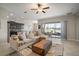 Open-concept living space features a comfortable sofa and sliding glass doors with lake views at 11717 Navajo Sandstone St, Riverview, FL 33579