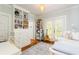 Comfortable bedroom featuring built-in shelving, hardwood floors, a desk, and natural light from the window at 1206 S Gunby Ave, Tampa, FL 33606