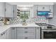 Updated kitchen featuring stainless steel appliances, attractive backsplash, and grey cabinetry at 2301 46Th S St, St Petersburg, FL 33711