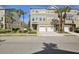 A tan townhouse with a two-car garage and palm trees in the front yard at 2967 Bayshore Pointe Dr, Tampa, FL 33611