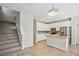 Open-concept kitchen with stairway, island sink, white cabinets, stainless appliances, and tiled backsplash at 2967 Bayshore Pointe Dr, Tampa, FL 33611