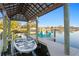 Covered boat lift showcasing a boat, private dock, and waterfront views with chairs at 3943 Fontainebleau Dr, Tampa, FL 33634