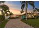 Inviting home with a brick driveway, palm trees, a well-manicured lawn, and a colorful front door at 3943 Fontainebleau Dr, Tampa, FL 33634