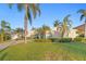 Well-maintained home has lush green lawn with mature palm trees and landscaped garden at 3943 Fontainebleau Dr, Tampa, FL 33634