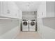 Clean laundry room featuring white cabinets and modern washer and dryer at 3943 Fontainebleau Dr, Tampa, FL 33634