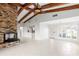 Bright living room featuring a brick fireplace, exposed wood beams, and abundant natural light at 3943 Fontainebleau Dr, Tampa, FL 33634