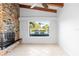 Bright living room featuring a brick fireplace, beamed ceilings, and a picturesque water view at 3943 Fontainebleau Dr, Tampa, FL 33634