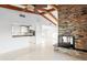 Open-concept living space showcasing a brick fireplace, tile flooring, and a partial view of the kitchen area at 3943 Fontainebleau Dr, Tampa, FL 33634