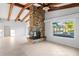 Spacious living area featuring a brick fireplace, large windows, and picturesque views of the outdoor pool and waterfront at 3943 Fontainebleau Dr, Tampa, FL 33634