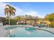 Travertine patio with a swimming pool, covered dock, lounge seating, and tropical landscaping at 3943 Fontainebleau Dr, Tampa, FL 33634