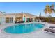 Beautiful pool area with travertine tile, backyard seating, outdoor kitchen, and tropical landscaping at 3943 Fontainebleau Dr, Tampa, FL 33634