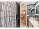 Bathroom with white ruffled shower curtain and decorative wallpaper at 4008 Passport Ln # 104, New Port Richey, FL 34653