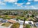 Wide aerial shot showcasing the neighborhood's layout, homes, and central green space under a bright blue sky at 5046 Rosewood Dr, New Port Richey, FL 34653