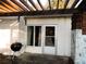 Covered patio area featuring concrete flooring, a grill, brick accents, and an access door at 528 Manor Dr, Dunedin, FL 34698