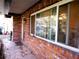 View of a brick house featuring a large window, trim accents, a doormat, and a portion of a paved surface at 528 Manor Dr, Dunedin, FL 34698