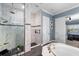 A luxurious bathroom featuring marble tiling in the dual showers and a soaking tub at 6326 Brevada Ln, Apollo Beach, FL 33572