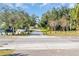 View of a neighborhood crosswalk leading to a grassy green space with mature trees at 7115 Edenwood Pl, Tampa, FL 33615