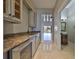 Hallway with wet bar, marble floors and bath access with neutral colored walls and bright lighting at 912 Symphony Beach Ln, Apollo Beach, FL 33572