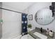 Well-maintained bathroom featuring modern fixtures, a stylish shower curtain, and a granite countertop at 9169 Robin Rd, Seminole, FL 33777