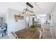 Bright dining room with a wooden table, modern light fixture, and view into the kitchen at 9169 Robin Rd, Seminole, FL 33777