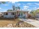 Charming home exterior featuring blue double doors, freshly painted stucco and a well-manicured front yard at 9169 Robin Rd, Seminole, FL 33777