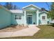 Inviting front entrance with a light-green exterior, a blue front door, and a well-manicured front yard at 9321 Regatta Cir, Spring Hill, FL 34606