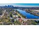 Aerial view of a home nestled among trees near a river with docks and a city skyline in the background at 1011 W Columbus Dr, Tampa, FL 33602