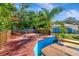 Wooden patio with a grill and plenty of seating with a privacy fence and lush landscaping at 1011 W Columbus Dr, Tampa, FL 33602