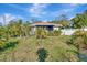Home with a well manicured lawn surrounded by lush, tropical landscaping and a white picket fence at 1011 W Columbus Dr, Tampa, FL 33602