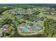 Aerial view of a community clubhouse with pool, parking, and surrounding landscape at 11018 Courtland St, Trinity, FL 34655