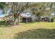Manicured backyard featuring a screened patio and mature trees at 11018 Courtland St, Trinity, FL 34655