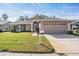 Charming single-story home showcasing a well-manicured lawn and a two-car garage at 11018 Courtland St, Trinity, FL 34655