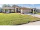 Inviting single-story home featuring a green lawn and an attached two-car garage at 11018 Courtland St, Trinity, FL 34655